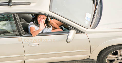 A woman in a car is waving goodbye through the side window