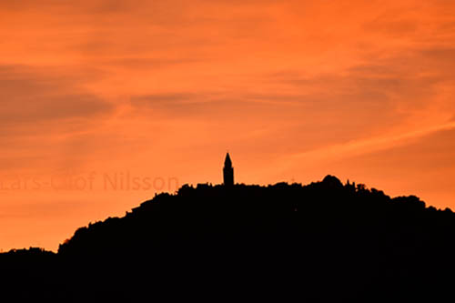 Sunset behind a town on a hilltop