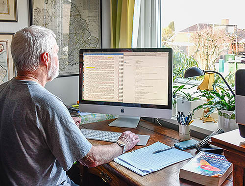 Man writing on a desktop computer. Is he a copy editor, a copy-editor or a copyeditor?