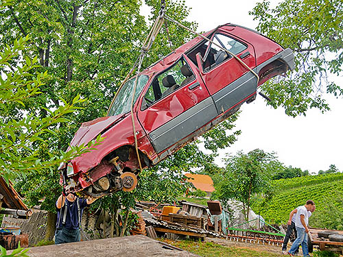 A crashed car is being lifted on to a tow truck. The image illustrates the phrase I couldn't care less.