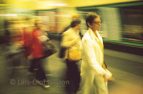 A few people are running in an underground station i London. The image illustrates the present continuous They were running to catch the train.