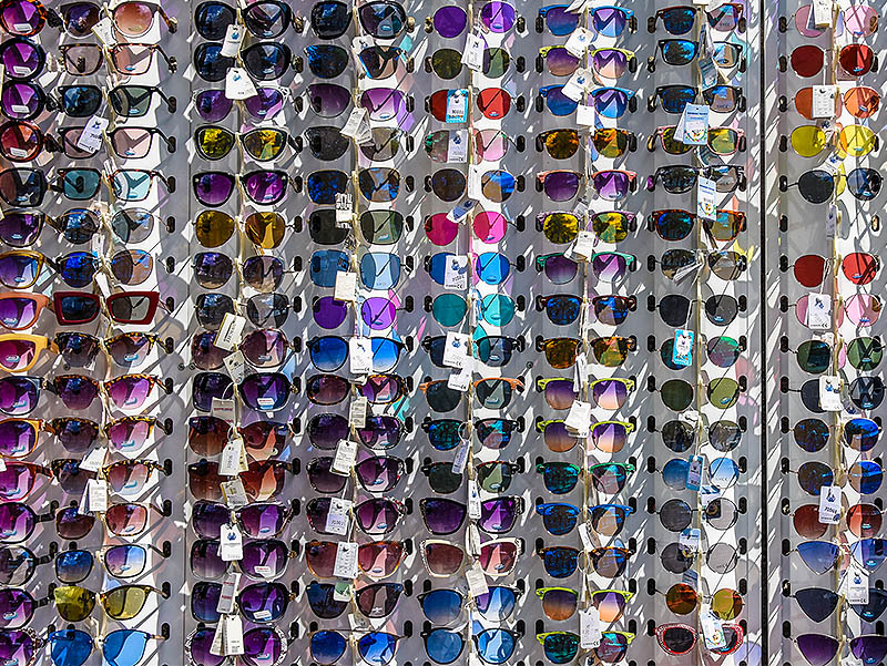 A display of various models and colours of sunglasses. The image illustrates the difference between different and various.