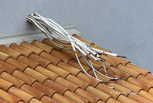 Insulated electrical cables sticking out of a wall. The image is used to illustrate a post about the difference between insulated and isolated