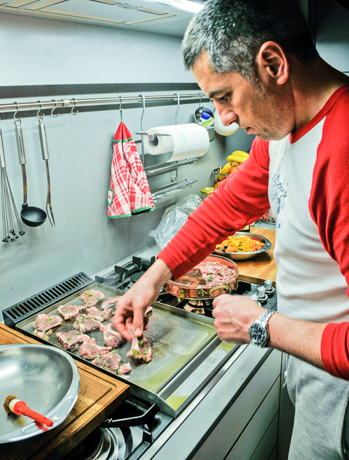 A man in a kitchen preparing dinner. The image is meant to illustrate the word adept.