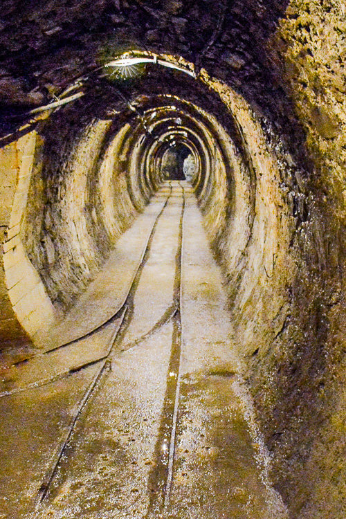 The image shows a gallery or mine passage in a mine and is intended to illustrate the use of the phrase at the end.