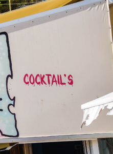 A sign outside a bar with the word cocktail's. The use of an apostrophe is wrong.