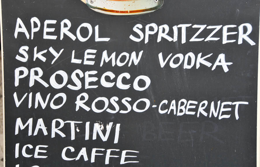 A sign in a bar offering a diverse drink menu.