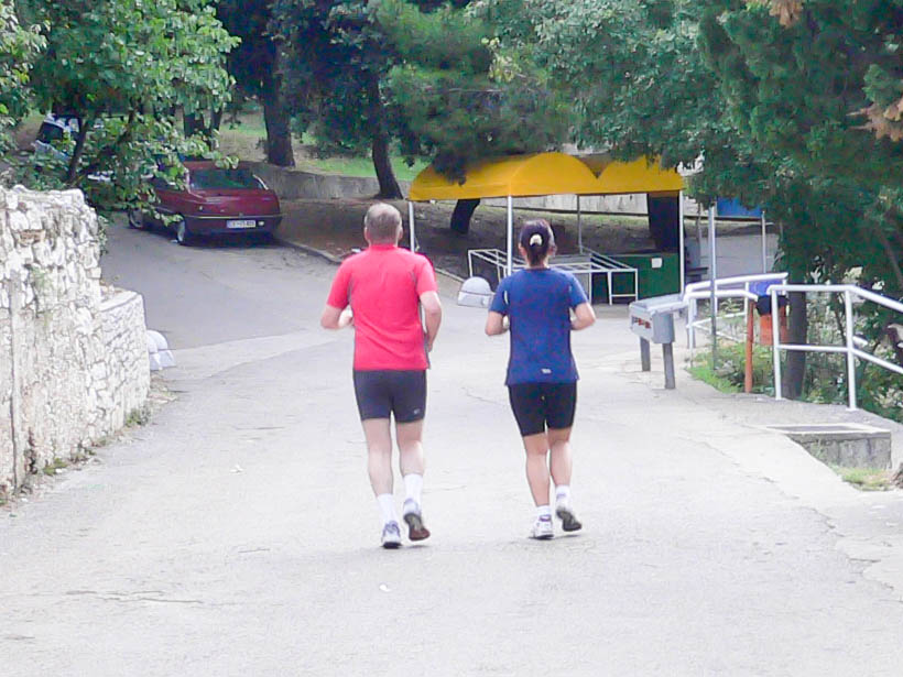 A man and a woman jogging side by side. The image illustrates the word concurrent, literally running together.